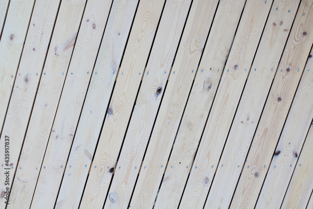 New unpainted wooden planks. Diagonal vertical view. Close-up. Background. Texture. New unpainted wooden planks. Diagonal vertical view. Close-up. Background. Texture.