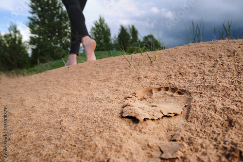 Wallpaper Mural woman walks barefoot on the sand. footprint in the sand Torontodigital.ca