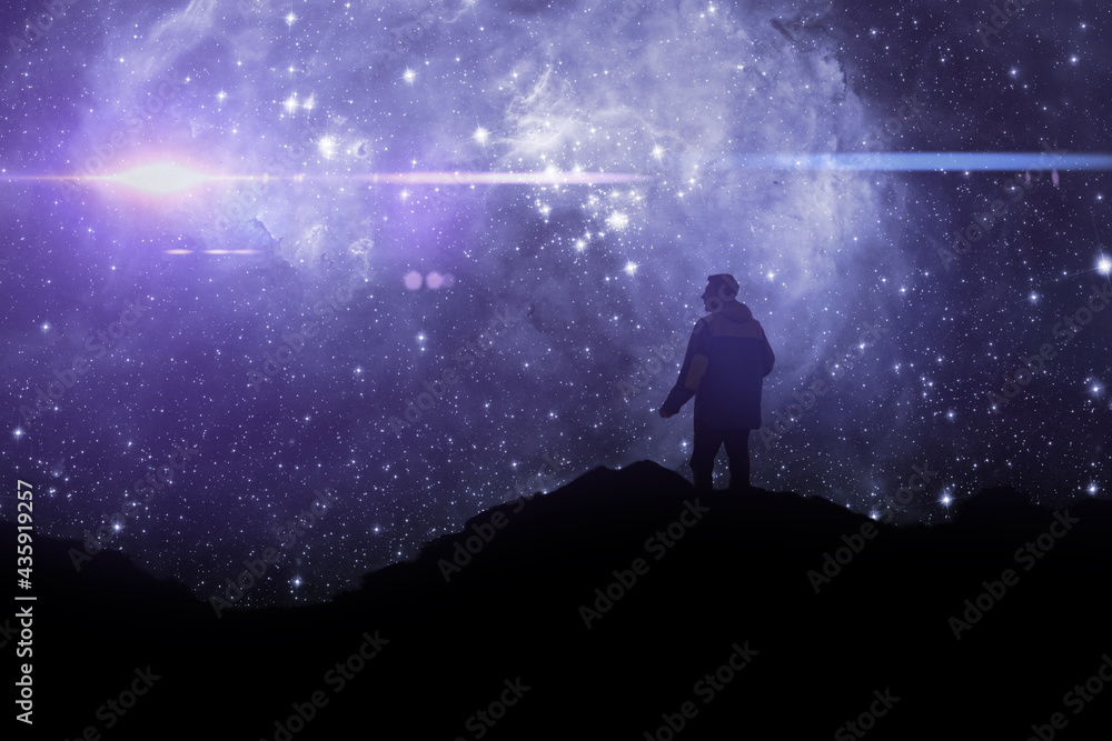 silhouette of a person standing on top of mountain and watch the sky galaxy. elements of this image furnished by nasa