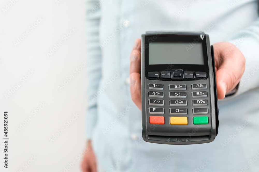 POS terminal or credit card reader machine on the white table with copy space. POS terminal or credit card reader machine on the white table with copy space.