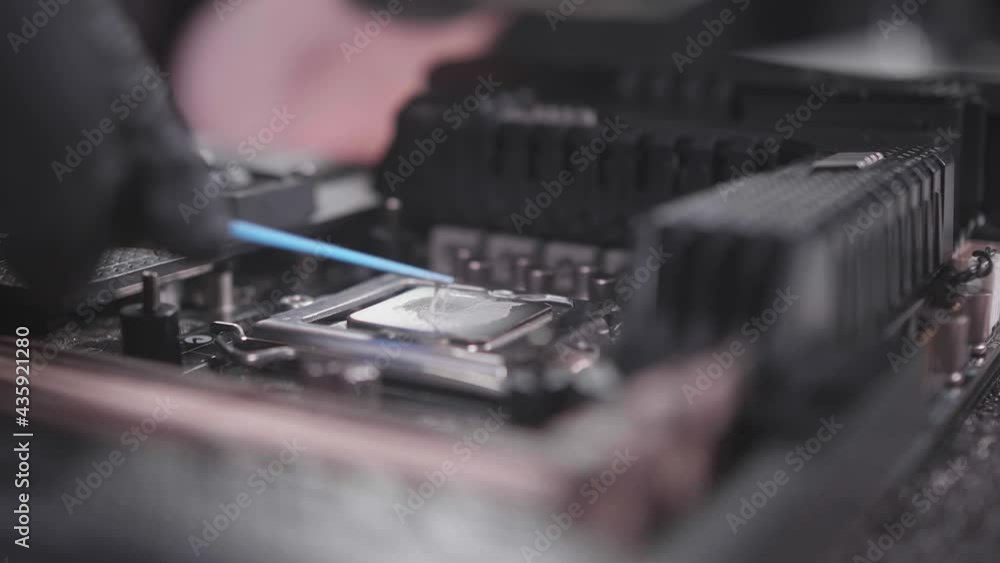 Technology of replacing thermo paste on the CPU close shot. Upgrade of computer components. Service for the repair and replacement of the computer motherboard. Technology of replacing thermo paste on the CPU close shot. Upgrade of computer components. Service for the repair and replacement of the computer motherboard.