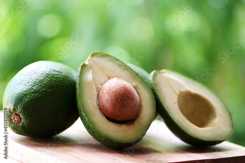 avocado and whole fruit on rustic wooden table photo