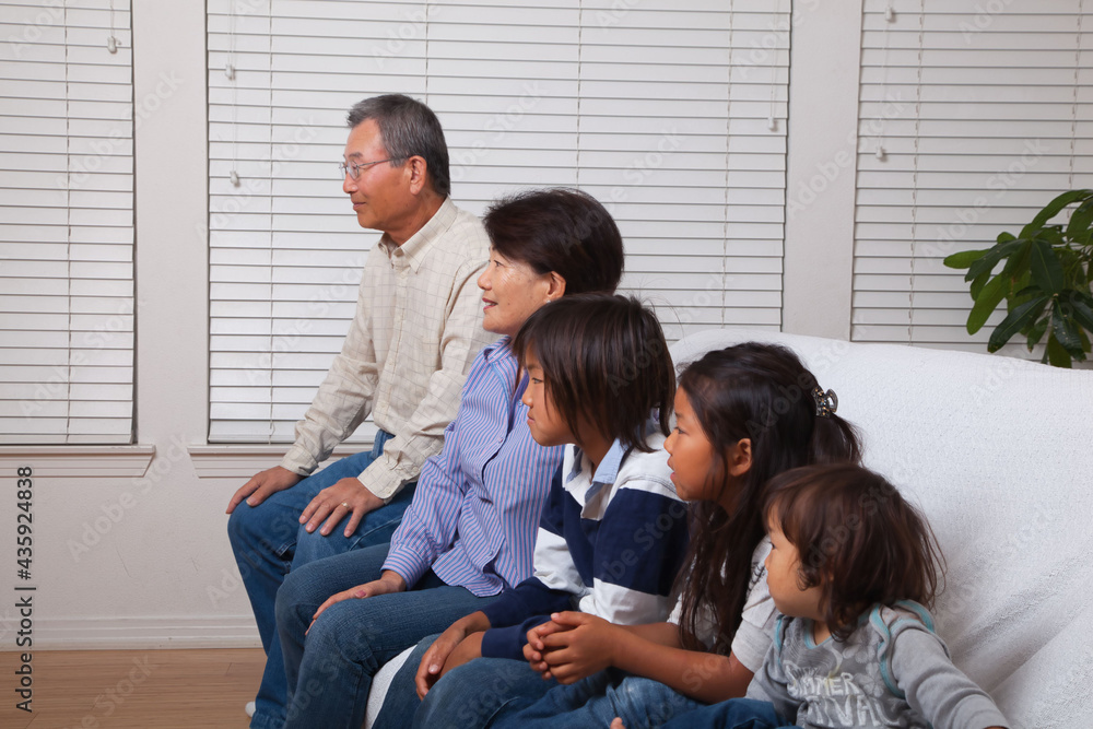 Japanese senior couple smiling at the camera with their grandchildren Japanese senior couple smiling at the camera with their grandchildren