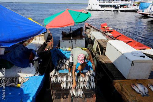 A fisherman works on top of his boat in Negro River, city of Manaus, Brazil.