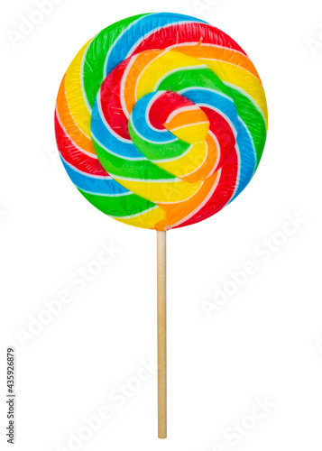 Colorful rainbow lollipop twisted on wooden stick isolated on white background. Caramel is spiral twisted into a large circle or round shape candy. Bright colors sugar sweet dessert. Close-up macro.