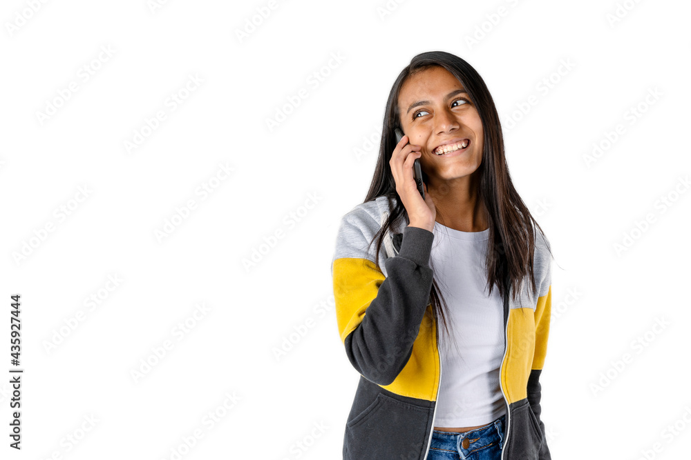 Fototapeta premium Attractive smiling latin woman talking on cellphone on white background. Technology and communications concept. Copy space.
