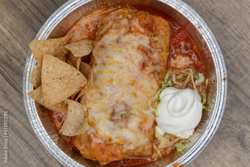 Bild auf Leinwand Overhead view of wet burrito smothered in melted cheese and served with rice and