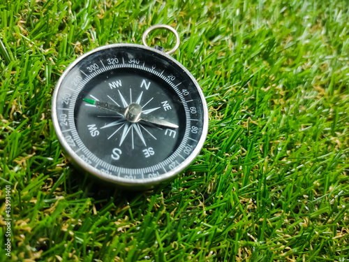 Compass on grass background. Travel concept.Compass with fresh green grass and copy space.