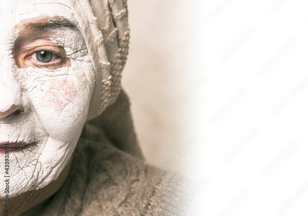 Elderly woman takes care of appearance, smiles in a white natural mask with vitamins for lifting, regenerating and rejuvenating the skin of the face. Pensioner makes beauty treatments in the bathroom. Elderly woman takes care of appearance, smiles in a white natural mask with vitamins for lifting, regenerating and rejuvenating the skin of the face. Pensioner makes beauty treatments in the bathroom.