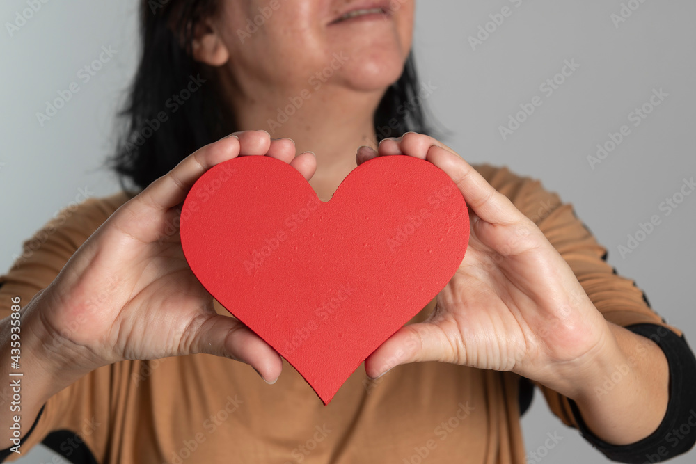 woman holding a heart design in front of her neck woman holding a heart design in front of her neck
