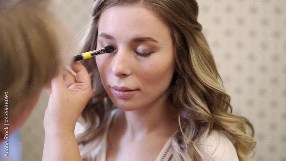 A beautiful girl with long hair do eye makeup. A beautiful girl with long hair do eye makeup.