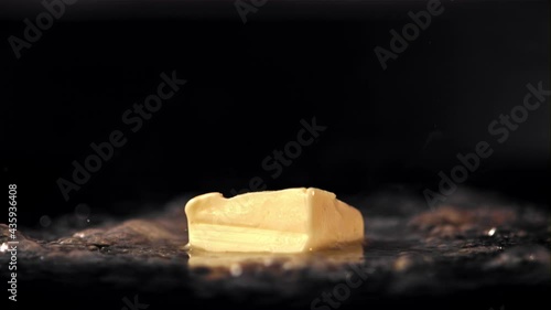 Super slow motion a piece of butter in a frying pan melts with hot steam. On a black background.Filmed on a high-speed camera at 1000 fps. High quality FullHD footage photo