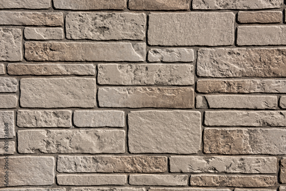 Obraz premium Japanese exterior wall cladding in a modern style lit with soft light and its surface in high relief alternating. Imitates brick wall.