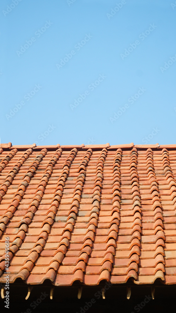 Orange roof tiles with blue sky background Orange roof tiles with blue sky background