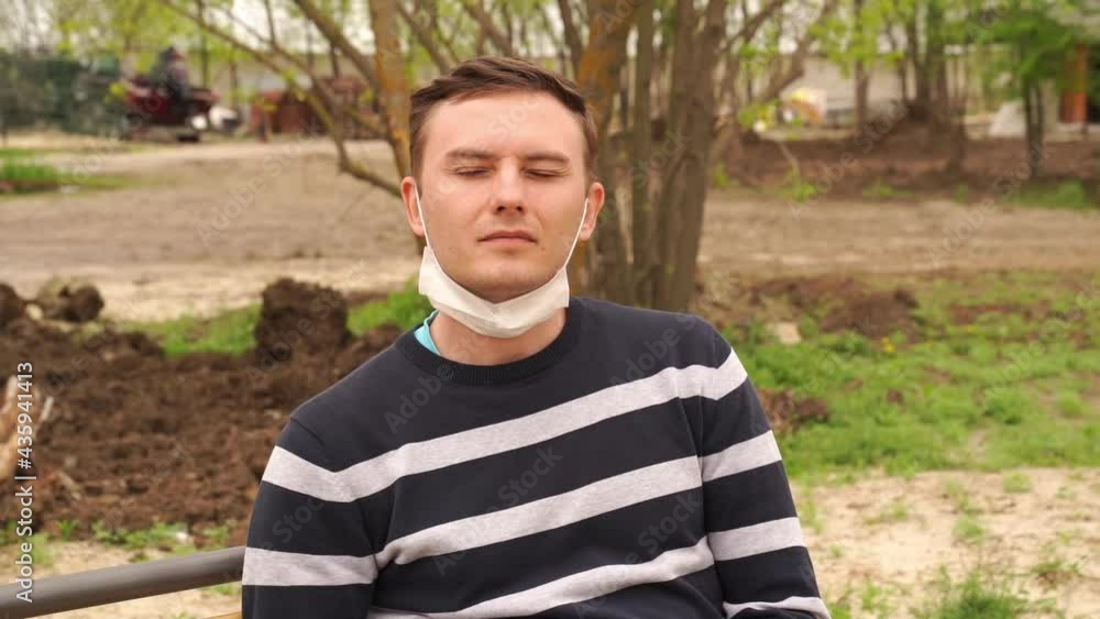 a man puts on a protective medical mask in the street. a man puts on a protective medical mask in the street.