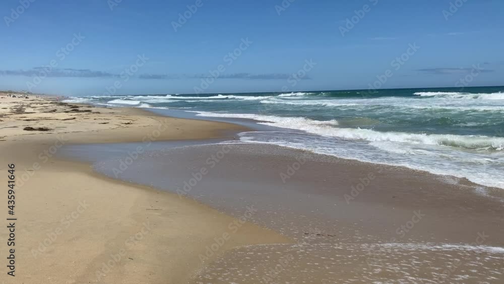 Beautiful sunny day on a calm pristine beach with blue skies in North Carolina in the Outer Banks in Nags Head during early summer Beautiful sunny day on a calm pristine beach with blue skies in North Carolina in the Outer Banks in Nags Head during early summer