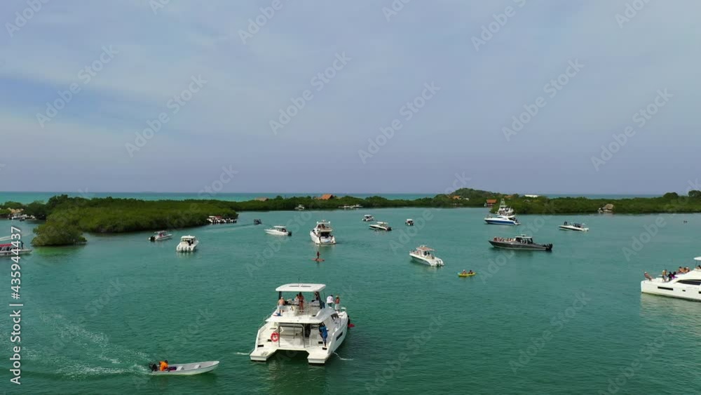 Aerial Backward Shot Of Boats Moving In Sea Against Sky, Drone Flying Over Rosario Islands On Sunny Day - Isla Baru, Colombia Aerial Backward Shot Of Boats Moving In Sea Against Sky, Drone Flying Over Rosario Islands On Sunny Day - Isla Baru, Colombia