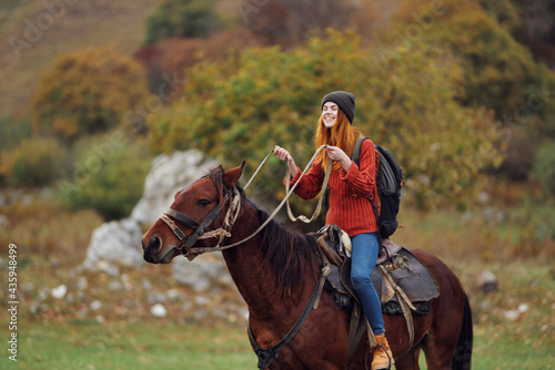 woman hiker riding a horse on nature mountains adventure