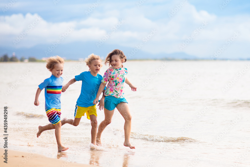 Kids playing on beach. Children play at sea.