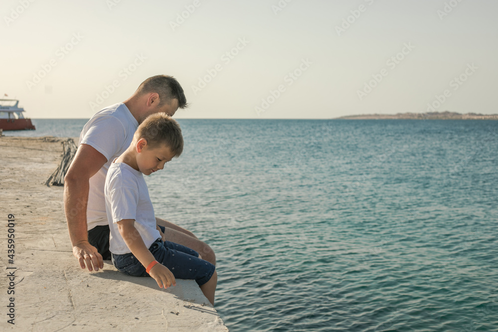 Father and son spending time together sea vacation. Young man, little boy walking beach Fathers day. Family with one child. Happy childhood with daddy. Father and son spending time together sea vacation. Young man, little boy walking beach Fathers day. Family with one child. Happy childhood with daddy.