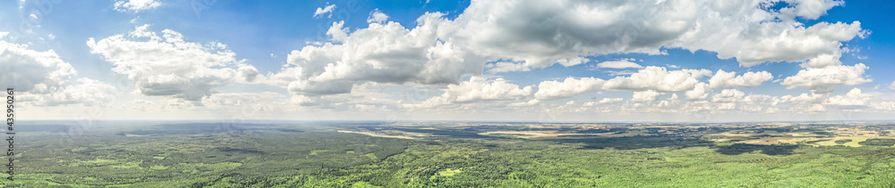 countryside landscape in sunny summer day under cloudy blue sky. panoramic aerial photo