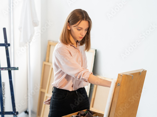 Art inspiration. Painting hobby. Creative talent. Imagination skill. Professional female artist drawing picture working in light home studio interior.