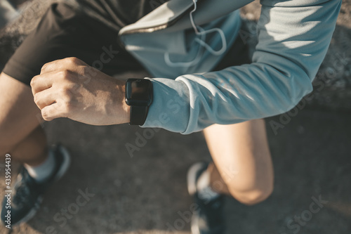 sport man checking at smartwatch during training and running in the park.