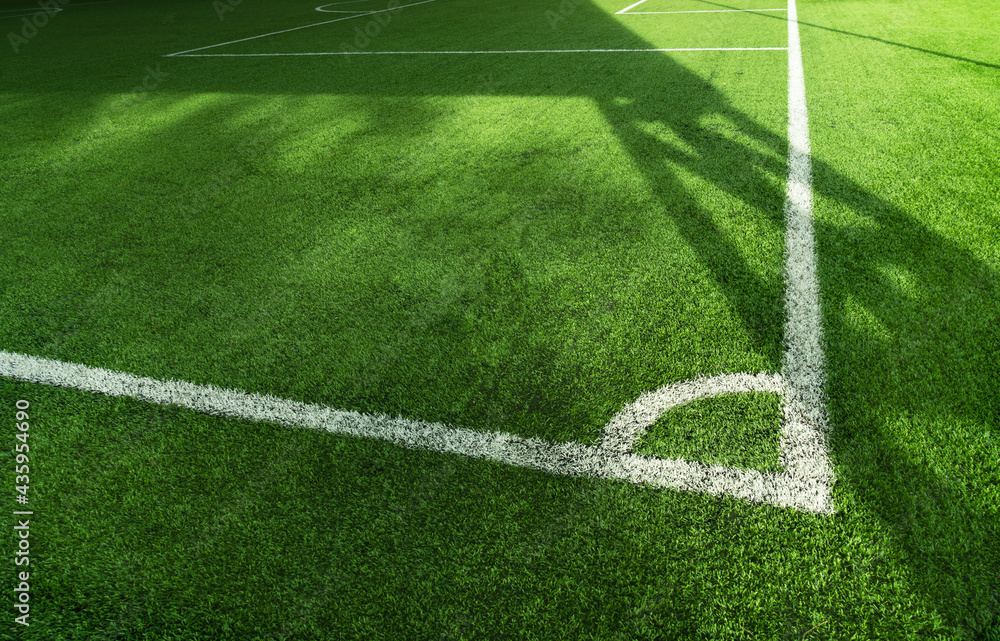 Obraz premium green artificial grass football or soccer field with white line background.