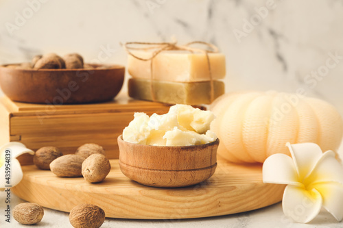 Shea butter  nuts and bath supplies on light background  closeup