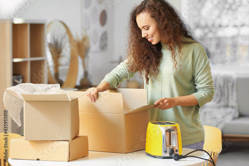 Young woman unpacking parce...