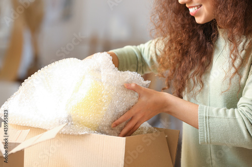 Young woman unpacking parce...