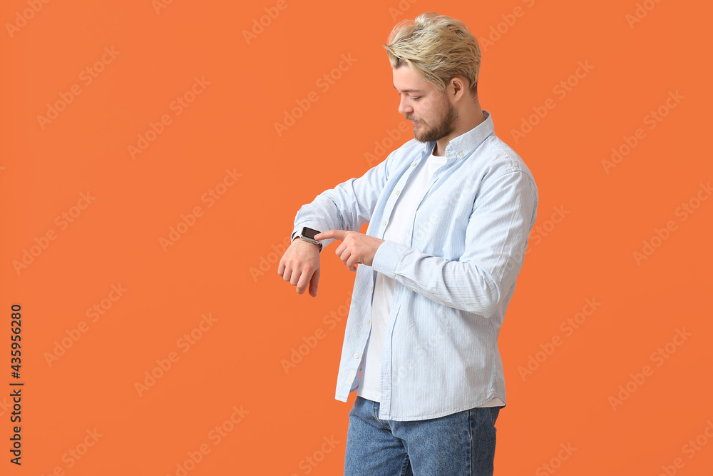 Young man with smart watch on color background Young man with smart watch on color background