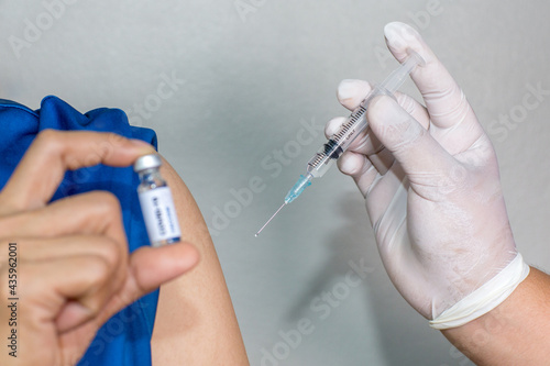 A woman showing a vaccine against the disease