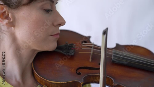 Close-up portrait of attractive female Tuning the Strings. Playing the violin. photo