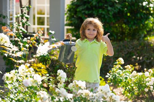Child watering a plant with watering can.