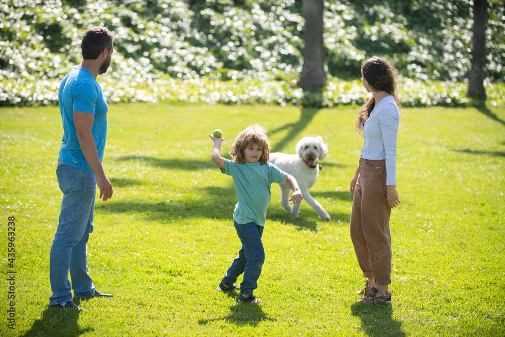 Portrait of a happy smiling family with dog relaxing in park.