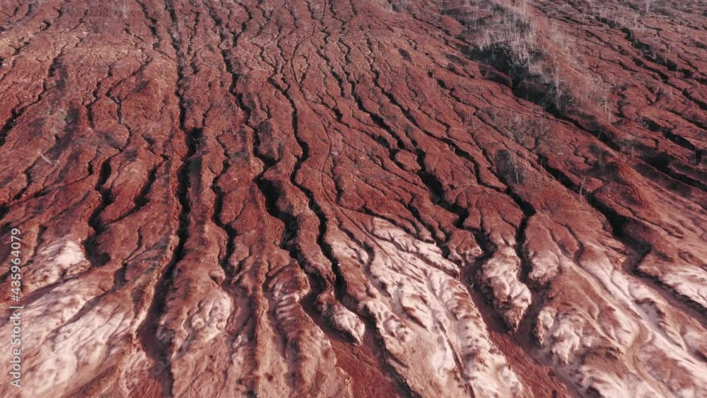 A landslide on the slope of a clay quarry. Lots of deep cracks on the surface of the red clay quarry. A landslide on the slope of a clay quarry. Lots of deep cracks on the surface of the red clay quarry.