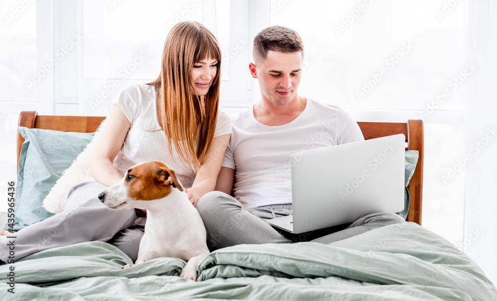 Couple in the bed with gadgets Couple in the bed with gadgets