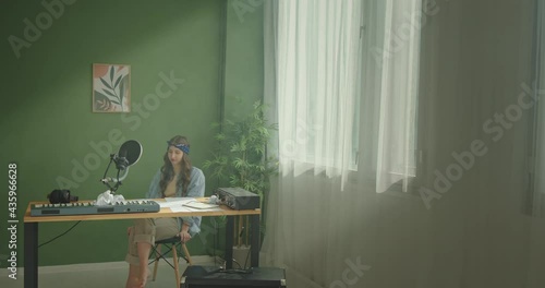 Young song writer creating music in room