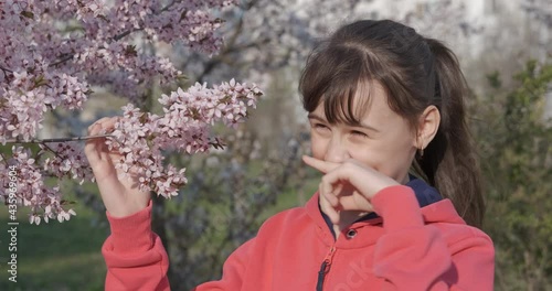 Teen with blooming branch. A young teen play and enjoy aroma of flowers from the tree in the spring meadow. photo