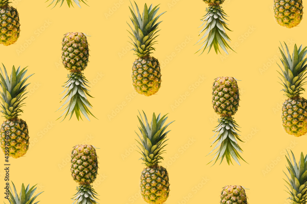 Pattern made of many modern, creative fresh exotic funky pineapples against illuminated yellow background. Levitating natural organic ananas summery concept. Pattern made of many modern, creative fresh exotic funky pineapples against illuminated yellow background. Levitating natural organic ananas summery concept.