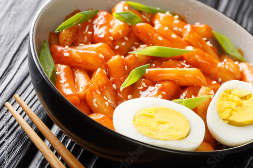 Tteokbokki also spelled ddukbokki, ddeokbokki, dukbokki or topokki is a beloved Korean rice cake dish close-up in a bowl on the table. horizontal photo