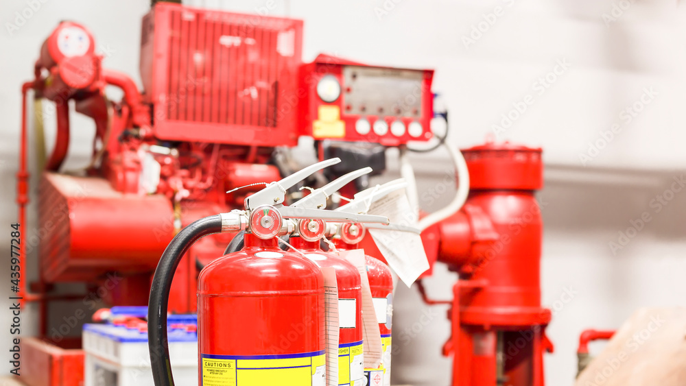 The red fire extinguisher is ready for use in case of an indoor fire emergency. The red fire extinguisher is ready for use in case of an indoor fire emergency.