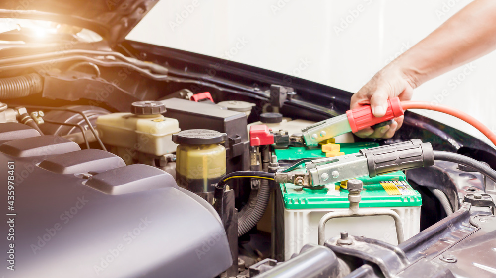 Close up Charging car battery with electricity through jumper cables. Close up Charging car battery with electricity through jumper cables.