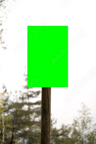 Empty information board on a wooden pole on the forest. Mock up attention sign in national park. Forest warning board.