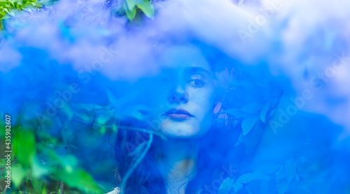 portrait of a young pretty woman, portrait of a woman in spring forest with blue smoke