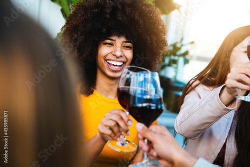 Sticker Happy african american woman drinking red wine at bar restaurant - Multiracial f