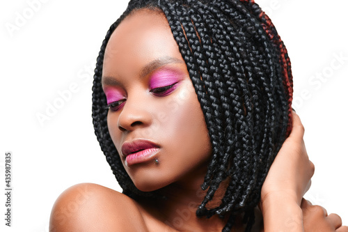 beauty portrait of an african american girl closed eyes. pink visage make-up. white background. isolate