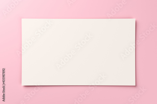 Blank white gift card on pastel pink background with copy space. 3D rendering
