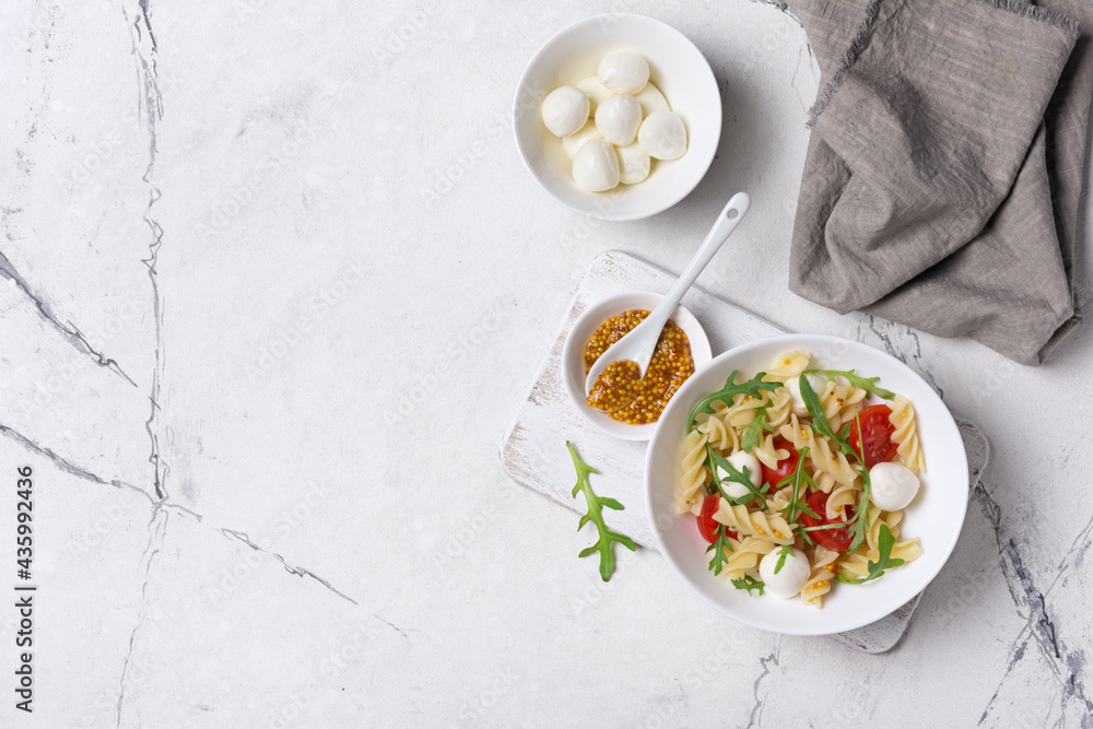 Pasta with cherry tomatoes, soft cheese, mustard sauce and arugula leaves Pasta with cherry tomatoes, soft cheese, mustard sauce and arugula leaves
